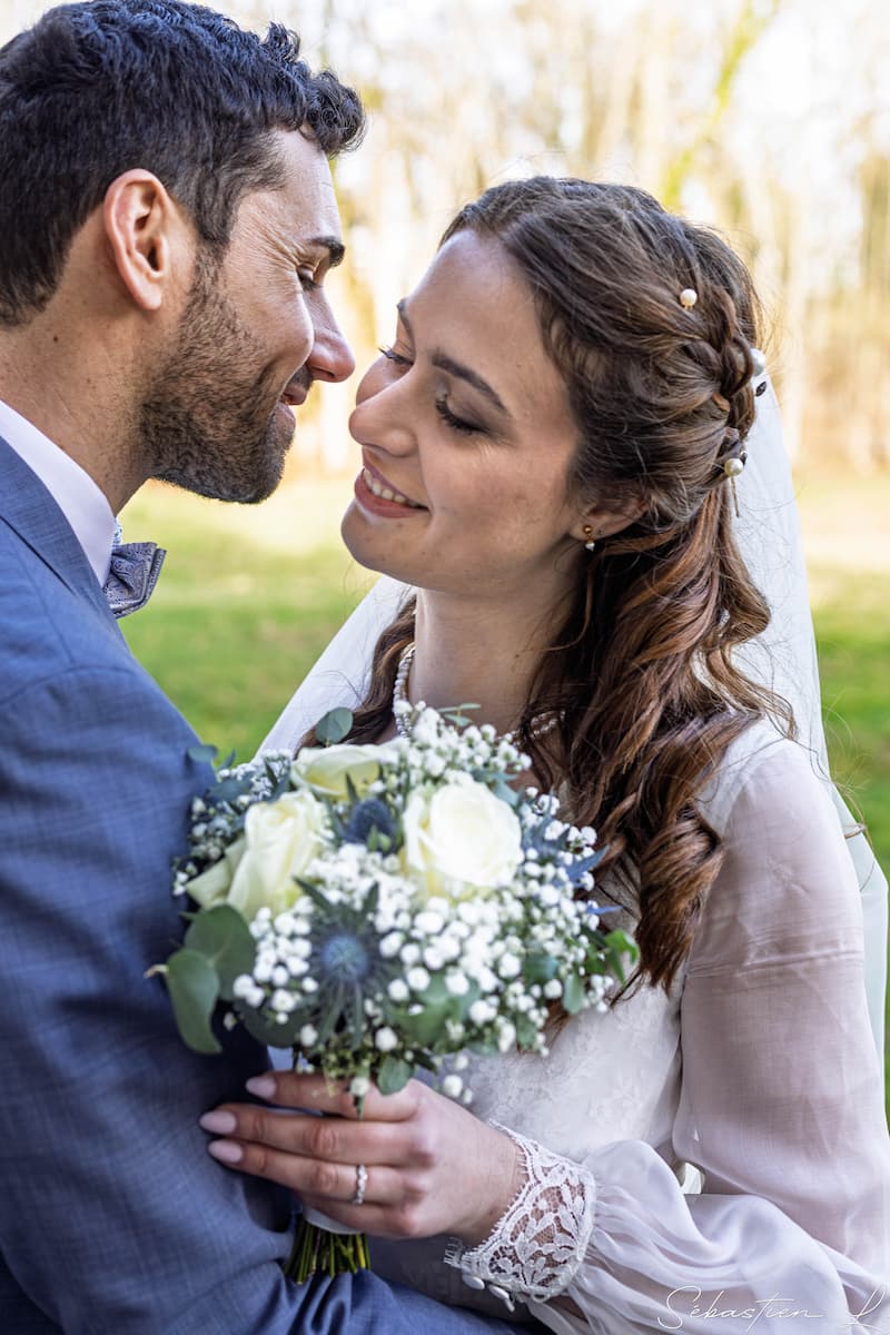 Portraits des mariés à travers un cadre tenu par leurs enfants qui se cachent les yeux